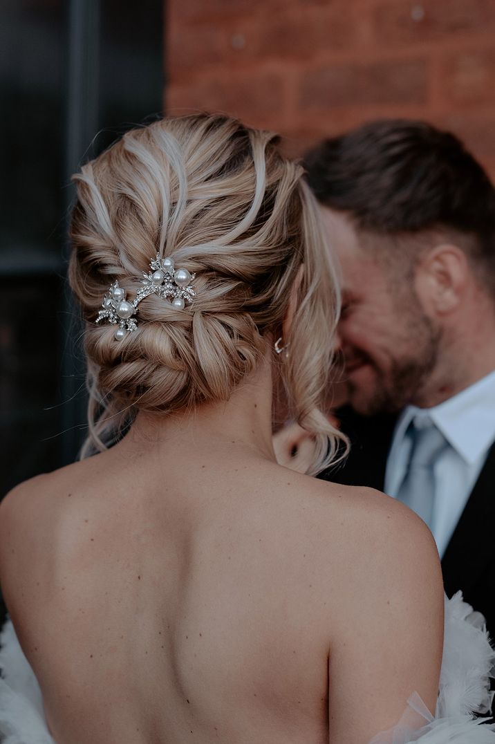 Intricate blonde updo with pearl and diamanté wedding hair accessories