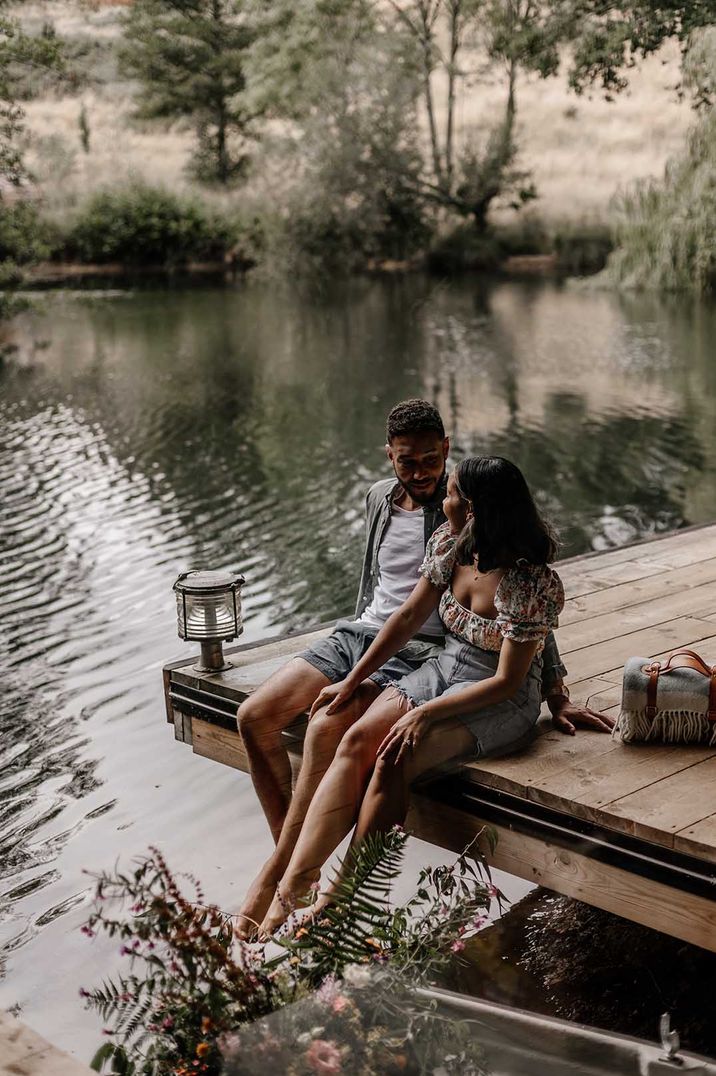 Couple sitting on a dock at their remote honeymoon