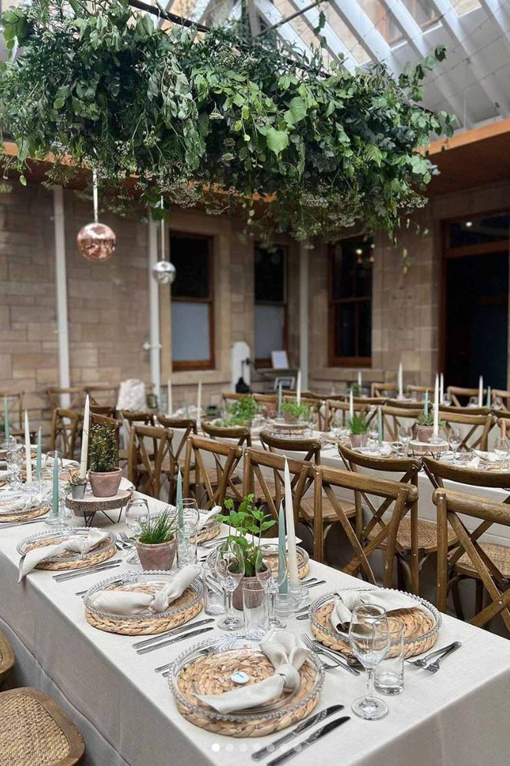 Cambo House Scottish wedding venue reception room with suspended foliage decor, disco ball decor, modern rustic wedding tablescapes and burlap place mats