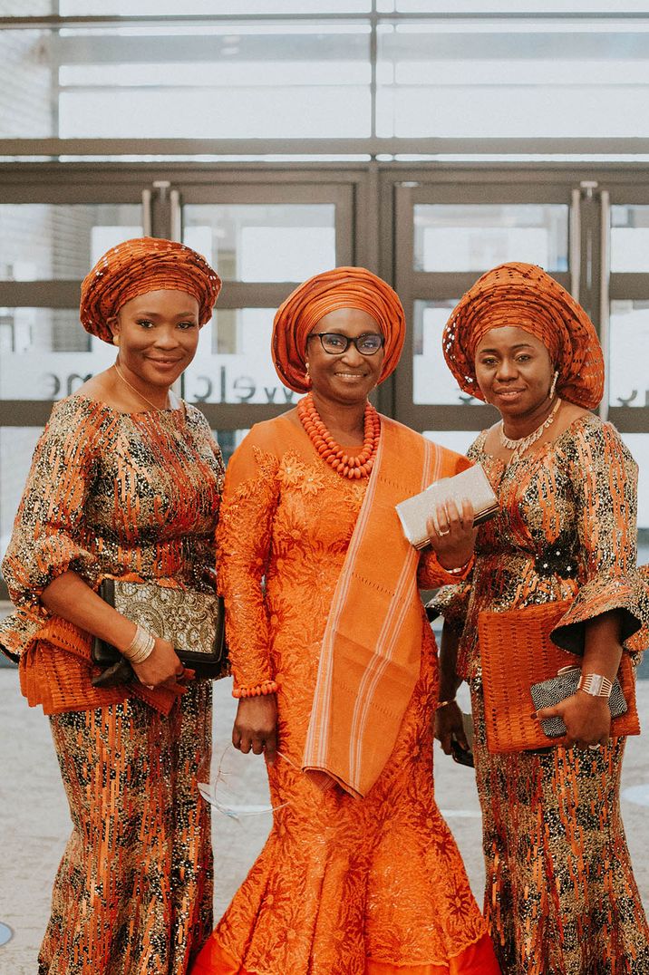 Wedding guests wearing bright and bold orange outfits as an autumn wedding idea