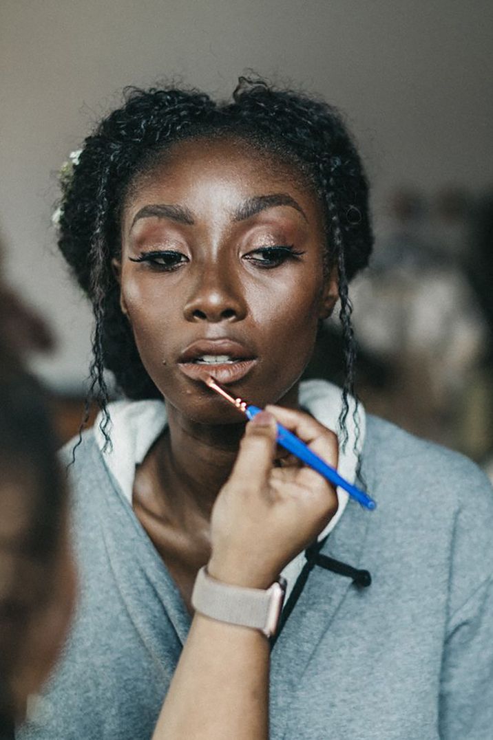 Bride gets her makeup done for the wedding day with a glowy base 