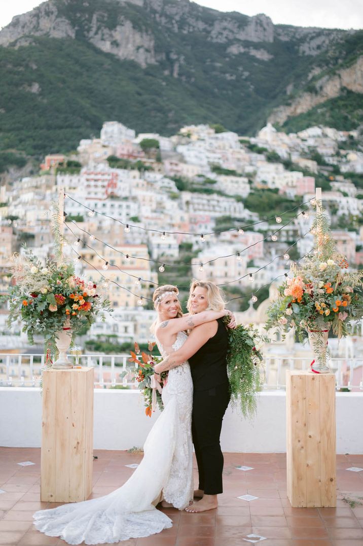 Couple hugging and laughing at the altar of their outdoor Italian wedding ceremony 