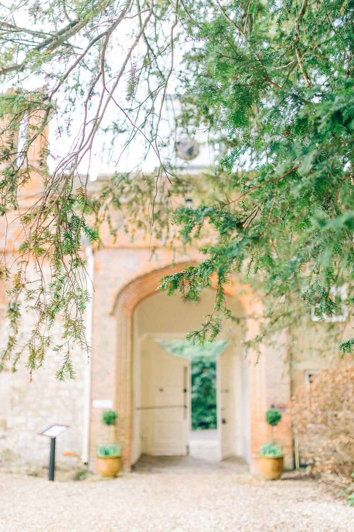 Grounds of Farnham Castle London wedding venue - large arches, ceramic plant pots and greenery 