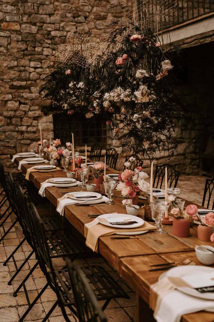 Classic rustic wedding tablescape with pink tapered candles and blush rose centrepieces at Barcelona wedding venue This Must Be The Place 