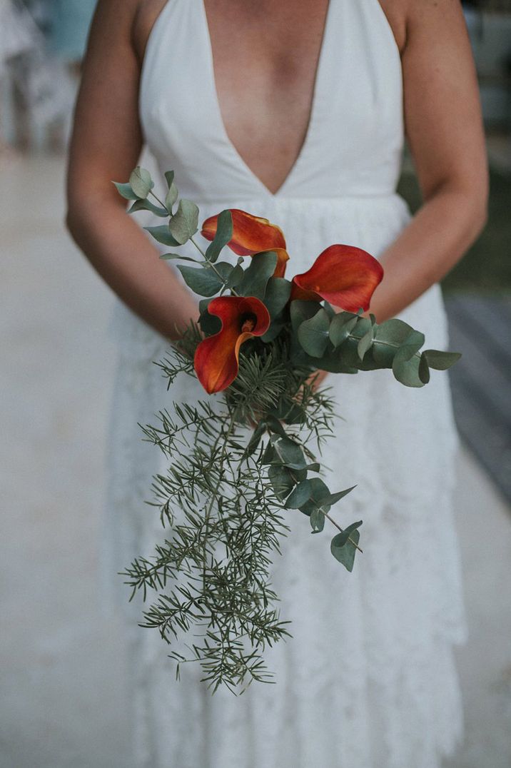 Red lily wedding bouquet with greenery and foliage 