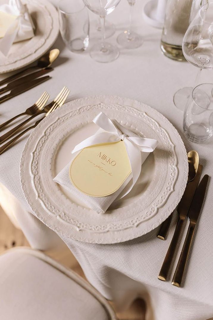 White plates with white tablecloths with yellow wedding place name sign for yellow theme wedding 