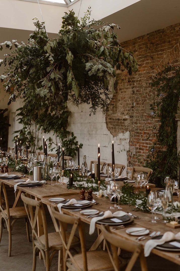 Wedding table with rustic decor, wooden chairs, greenery and black candles in the Fig House at Middleton Lodge