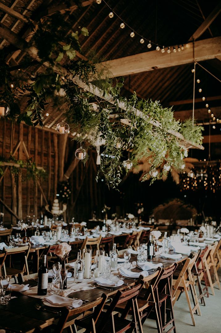 Converted cattle shed into a boho wedding with hanging festoon light and foliage installation