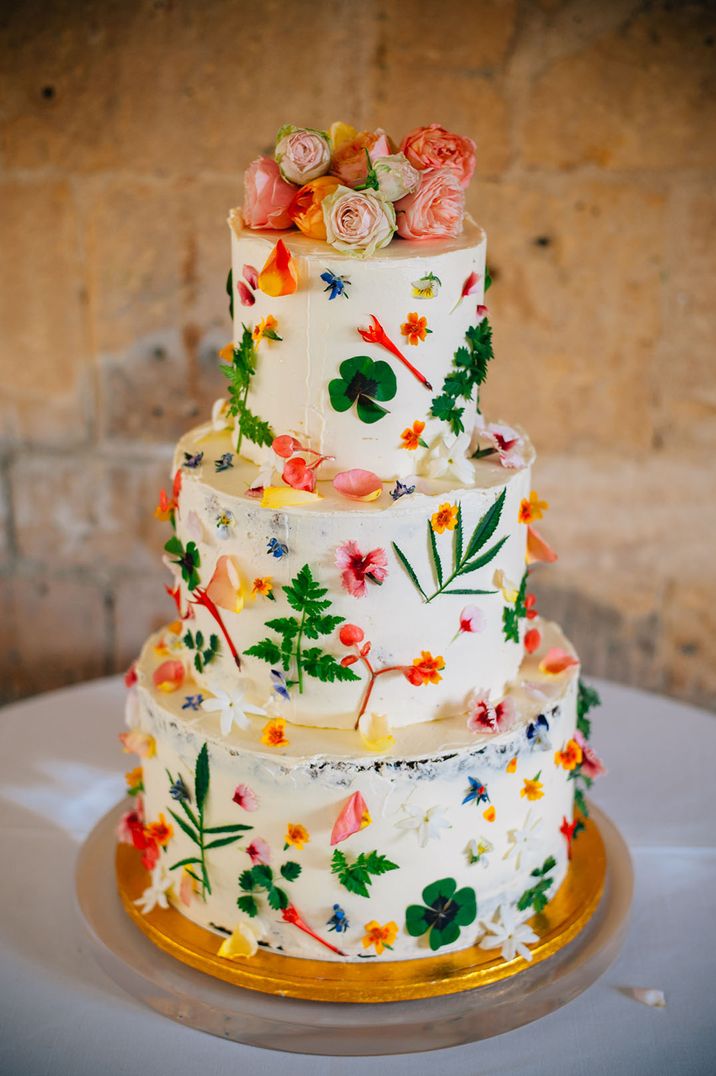 Three tier white wedding cake decorated with bright flower for botanical wedding cake 