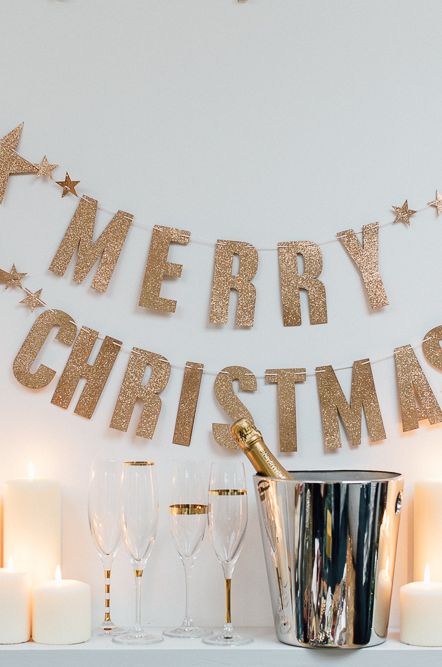 Merry Christmas banner, champagne in a champagne bucket with pillar candles 