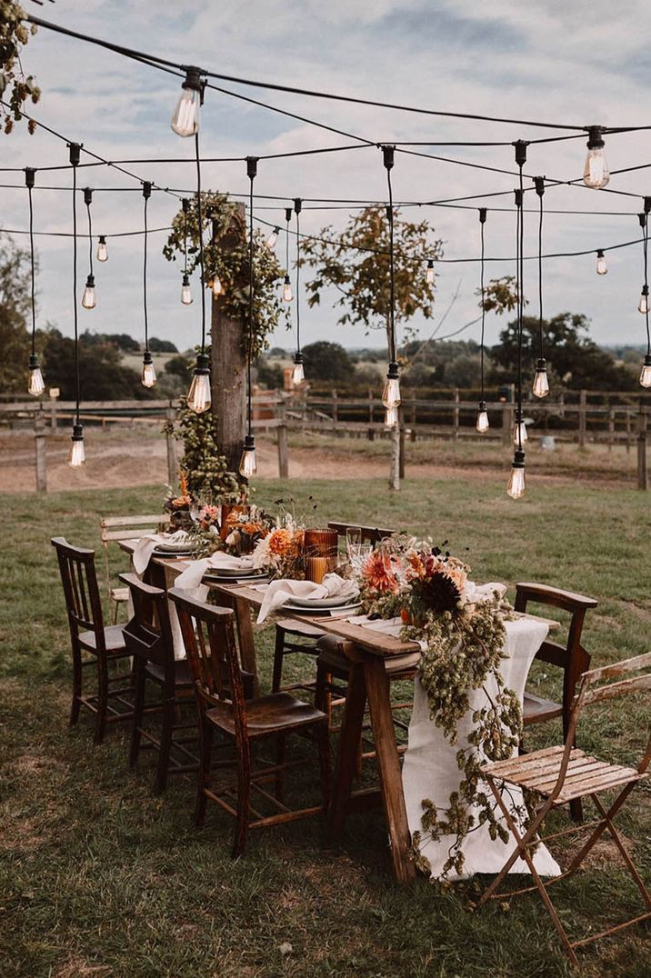 Outdoor wedding tablescape at farm wedding venue in Surrey with disco ball decor, festoon lighting and more 