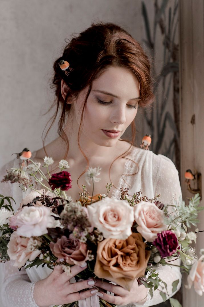 Bride carrying neutral wedding bouquet with toffee roses, light pink roses and more 