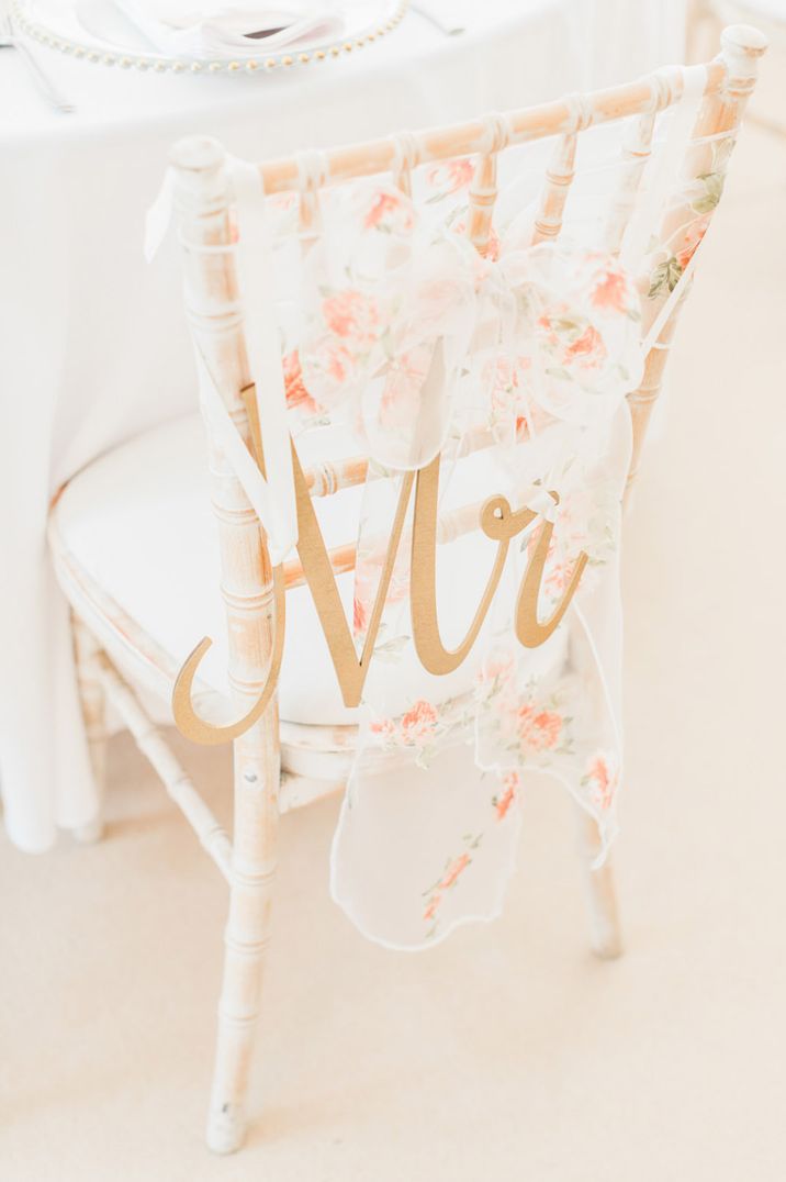 Sheer floral patterned wedding bow with a gold laser cut Mr wedding sign for the wedding chair decor