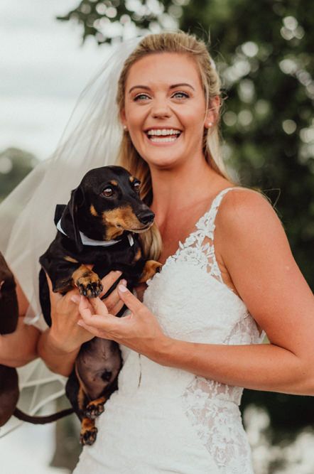 Two brides at Micklefield Hall wedding holding their pet Dsuschunds 