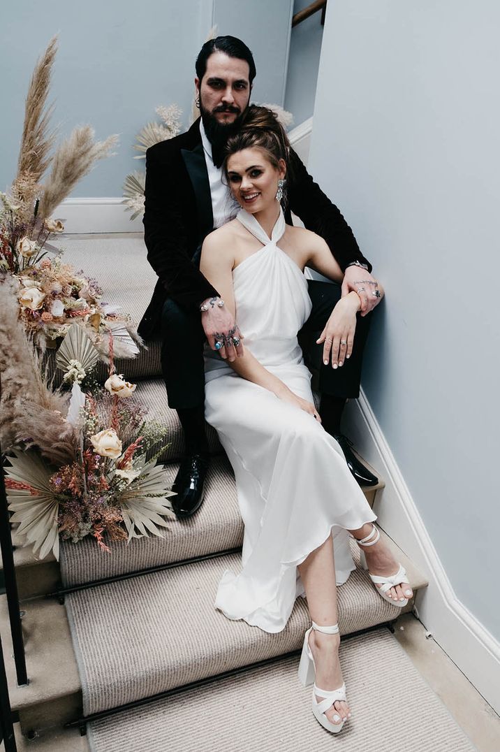 Pastel theme wedding with the bride in a halter neck slip dress for wedding with the groom in velvet suit jacket 