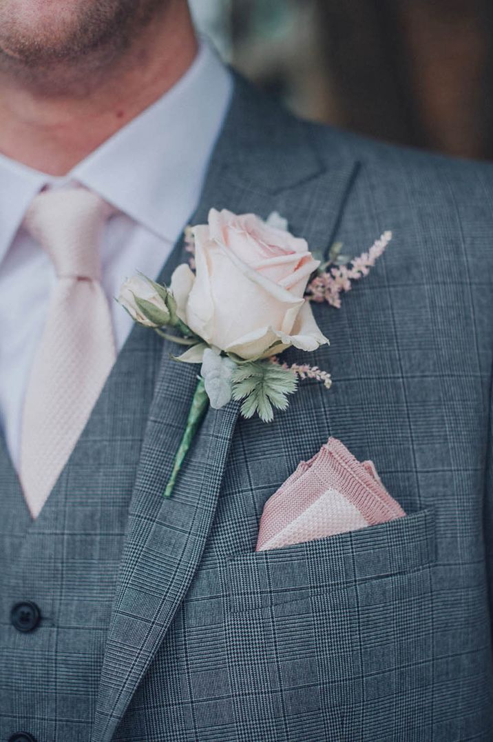 Pink theme wedding with groom in a grey suit with pink rose buttonhole, pink tie and pink pocket square 