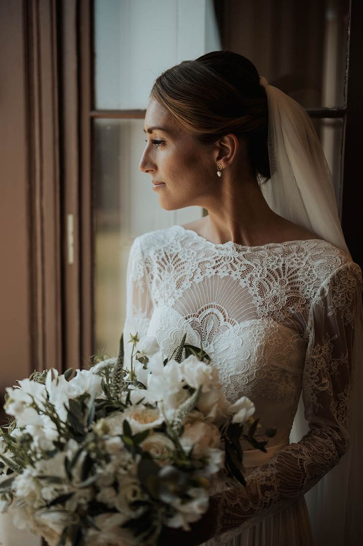 Bride wearing winter wedding dress with long sleeves and high neck detail 