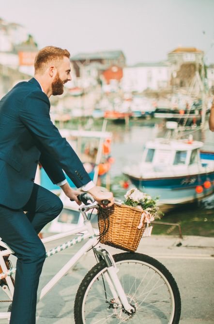 Couple on tandem bike by the sea with wicker basket and floral display