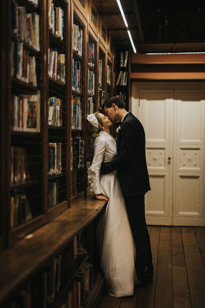 The bride and grooms share a kiss in the library in an iconic remake of the kiss in Bridgerton season one 