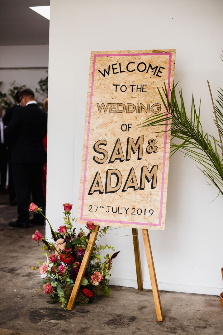 Contemporary chipboard wedding sign and bright wedding flowers