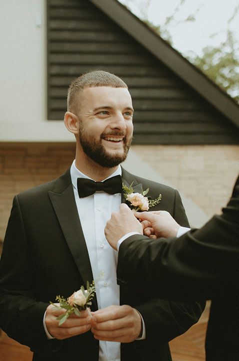 Groom in bowtie with neutral boutonniere 