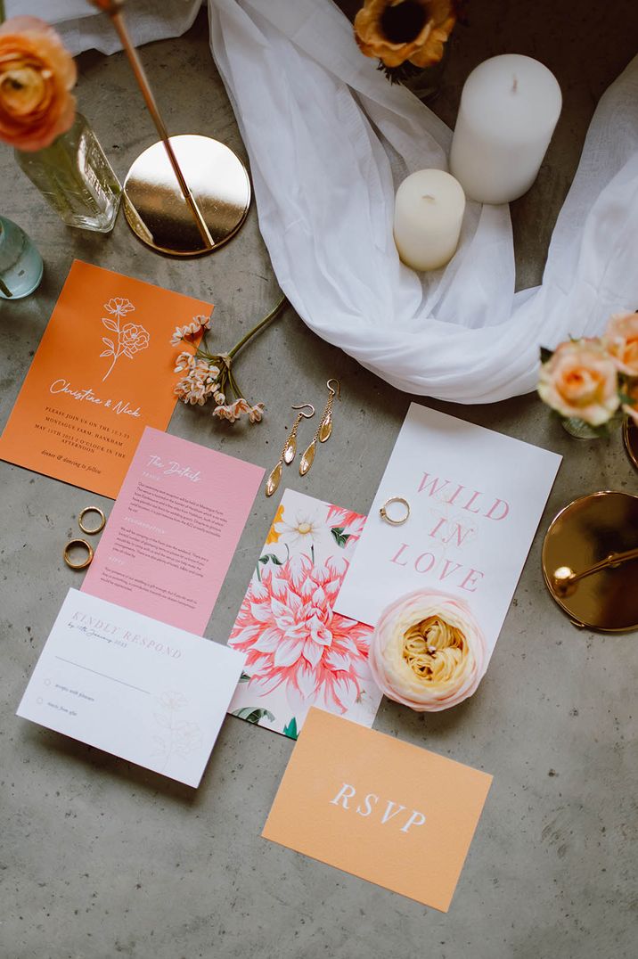 Orange white and pink simplistic wedding stationery with white tulle table runners and pillar candles 