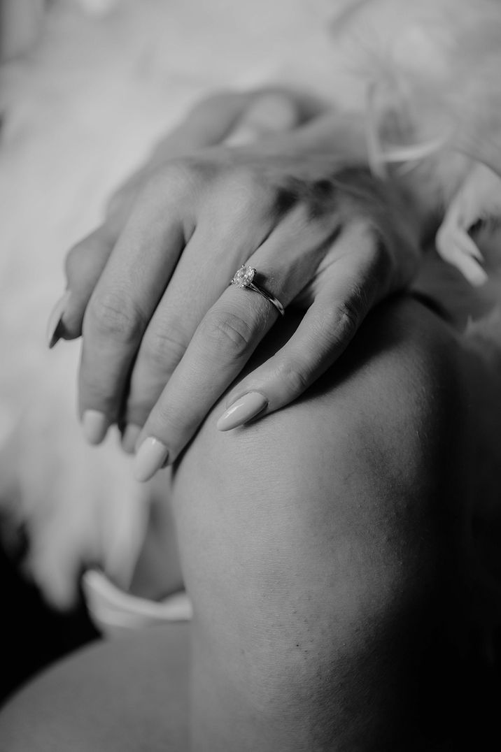 Bride wearing a diamond engagement ring with almond nails 