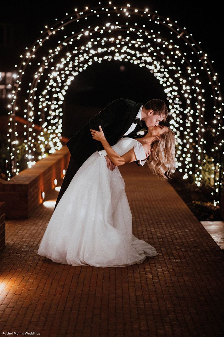 Groom sweeps the bride in a passionate kiss at barn wedding 