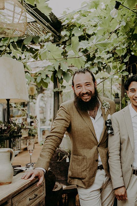 The groom and groomsmen walk arm in arm together 