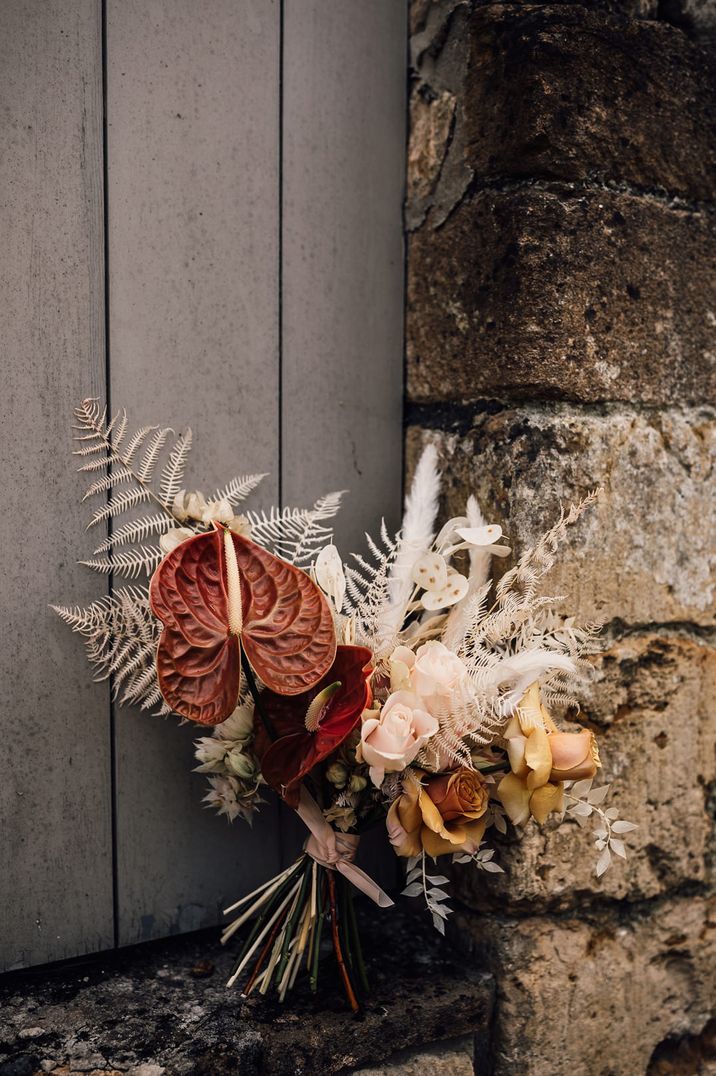 Boho wedding bouquet with neutral dried grasses and brown anthurium flowers 