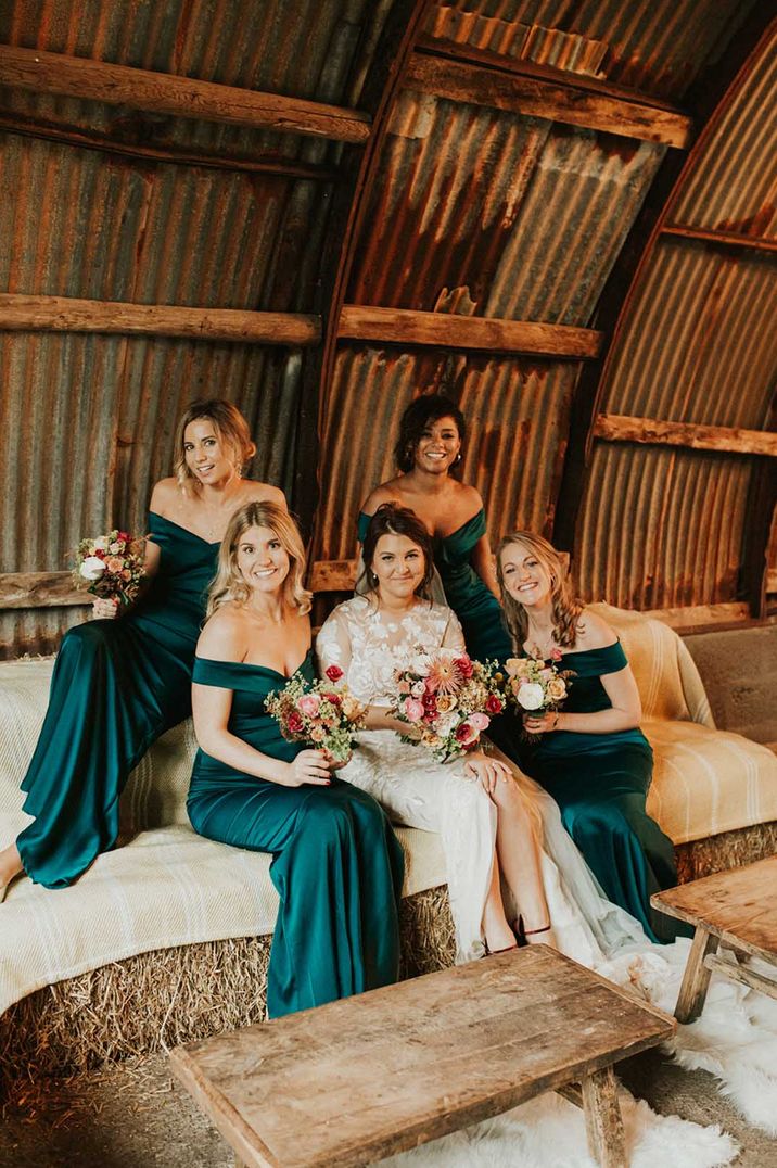 Bridesmaids in off the shoulder emerald green bridesmaid dresses with bride in high neck illusion lace wedding dress 