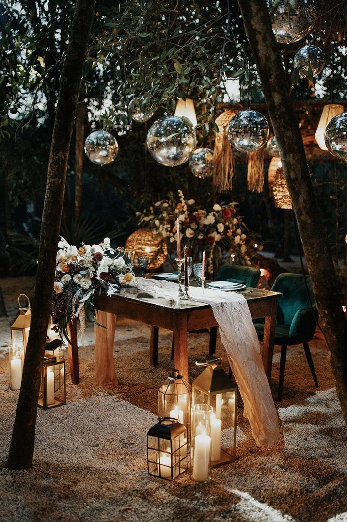 Outdoor Mayan wedding with sweetheart table with disco balls, drapery and soft lighting 