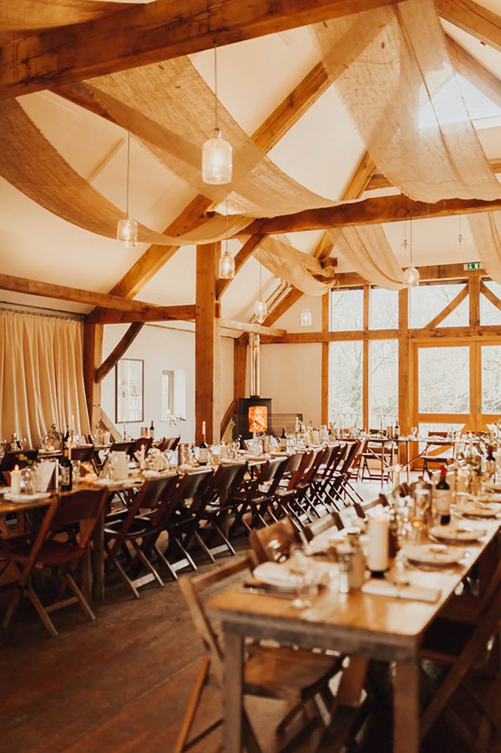 Rustic barn wedding venue, Nancarrow Farm decorated with drapery to complement rustic beams 