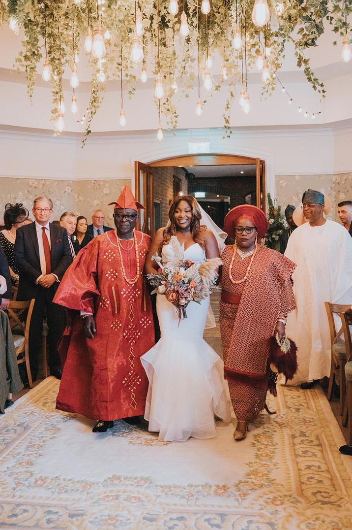 Bride walked down the aisle by both of her parents 