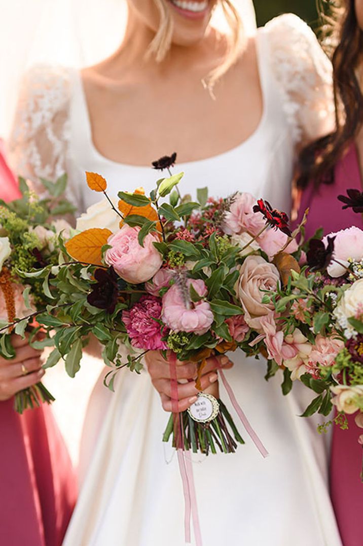 Pink and red wedding bouquet held by bride and bridesmaids 