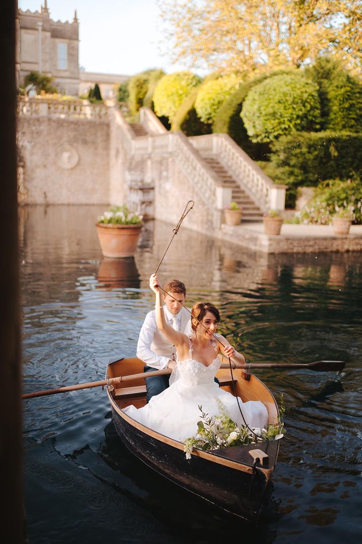 Couple in black rowboat, bride wearing strappy wedding dress with full skirt