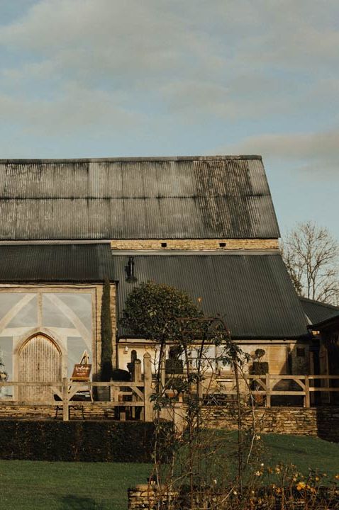 How to choose your wedding venue - converted barn venue with wooden signs and plant pots