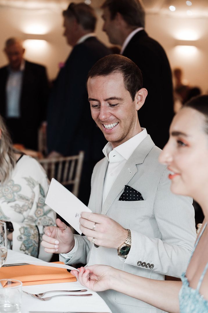 A wedding guest reacts to their personalised wedding poem favour idea 