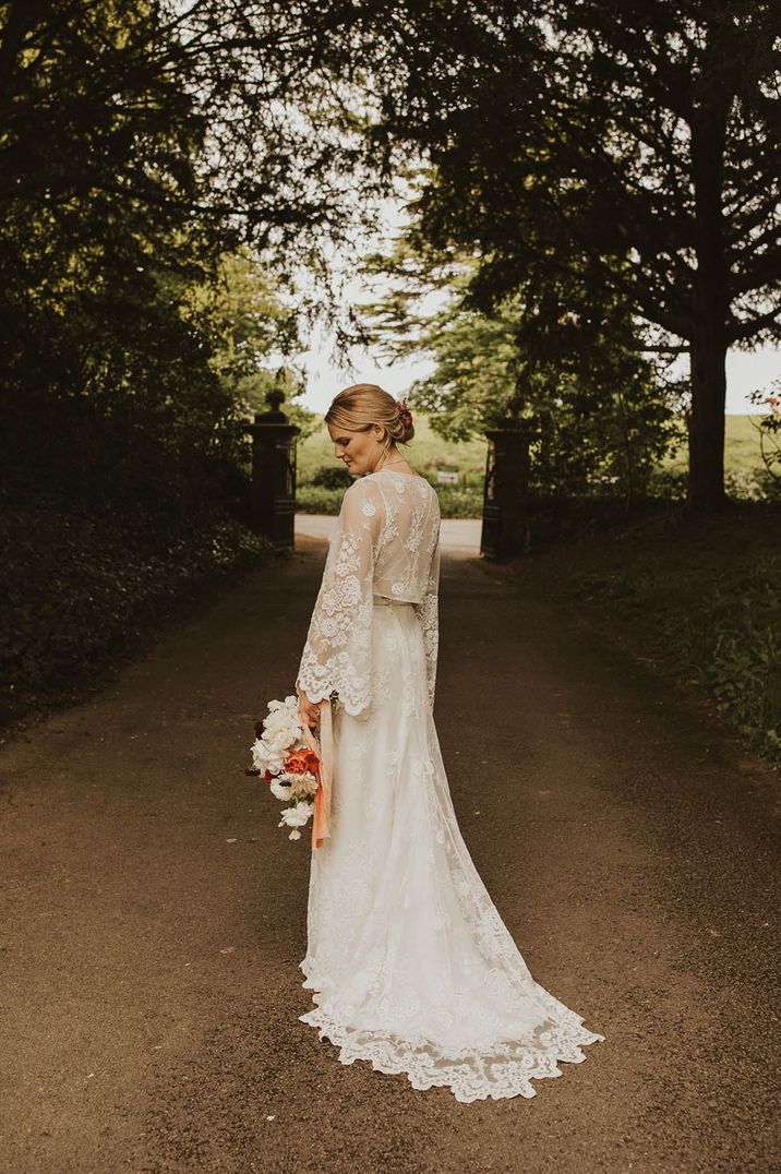 Bride wearing a lace long sleeve wedding dress with neutral wedding bouquet 