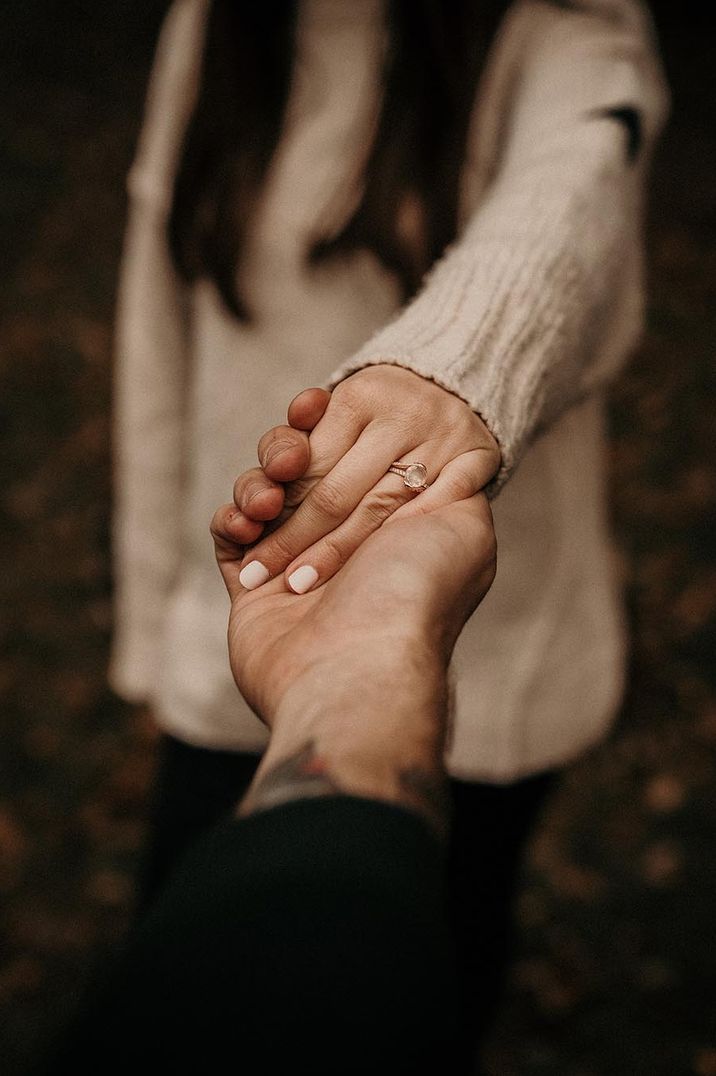 Marriage proposal with bride wearing a cream jumper showing off her rose gold oval engagement ring 