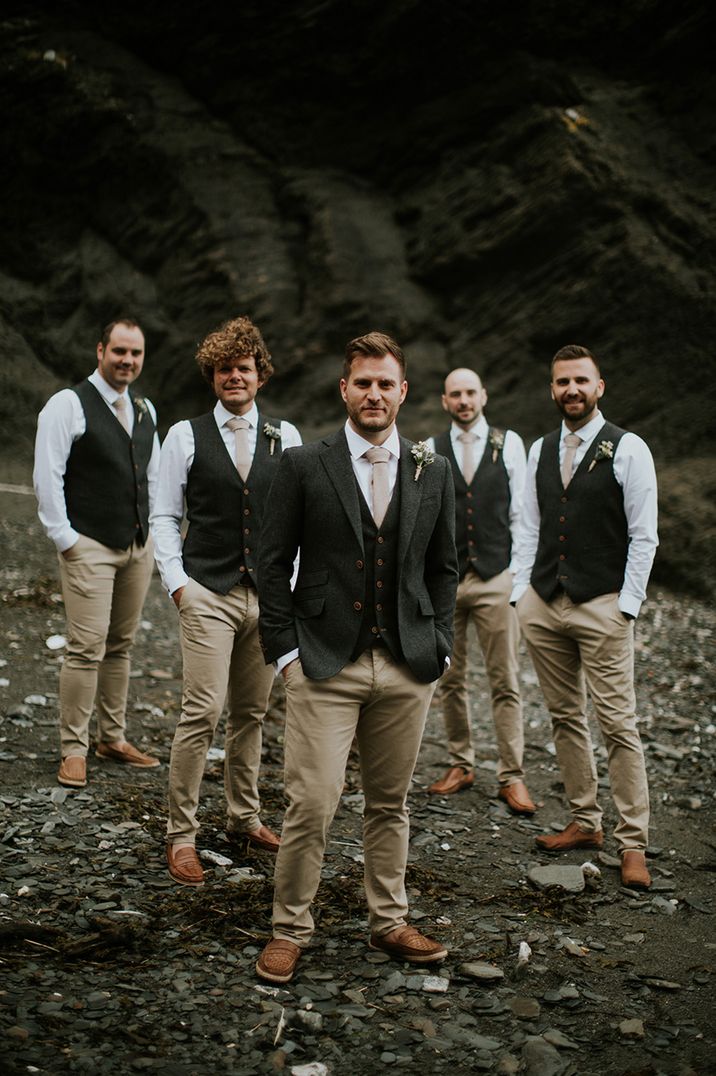 The groomsmen stand in a V-formation for their group party photo 