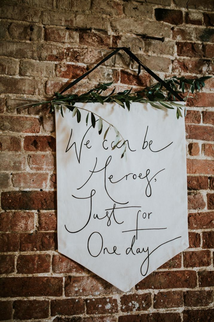 Flag wedding sign with "We can be heroes, just for one day" quote