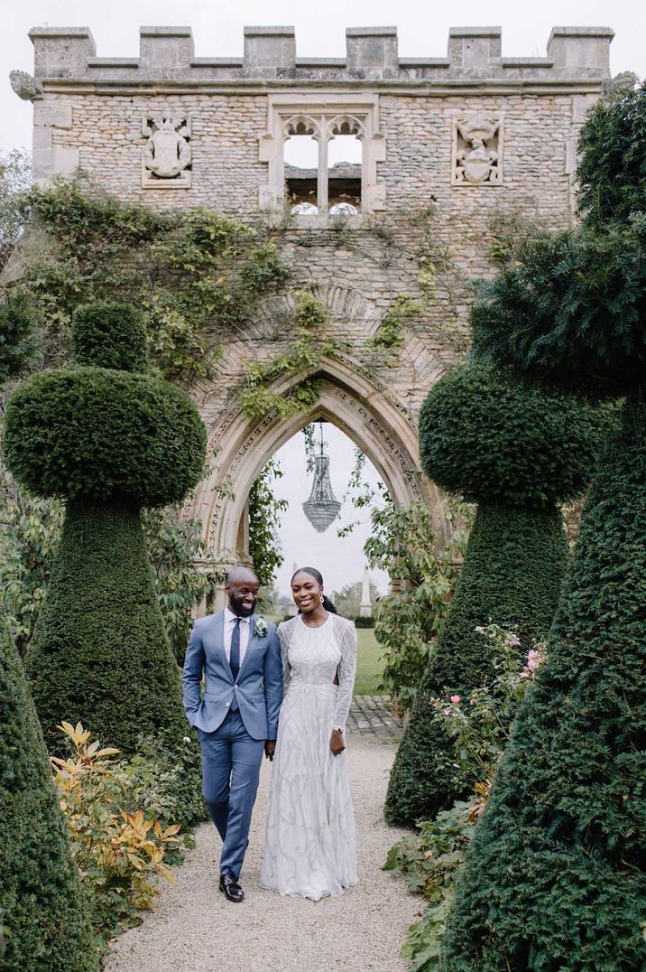 Bride and groom walk around the grounds of Euridge Manor wedding venue with a chandelier decoration 