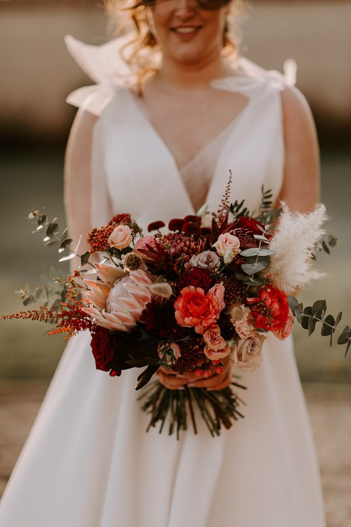 King proteas, berries, bunny grass and more in red festive wedding bouquet 