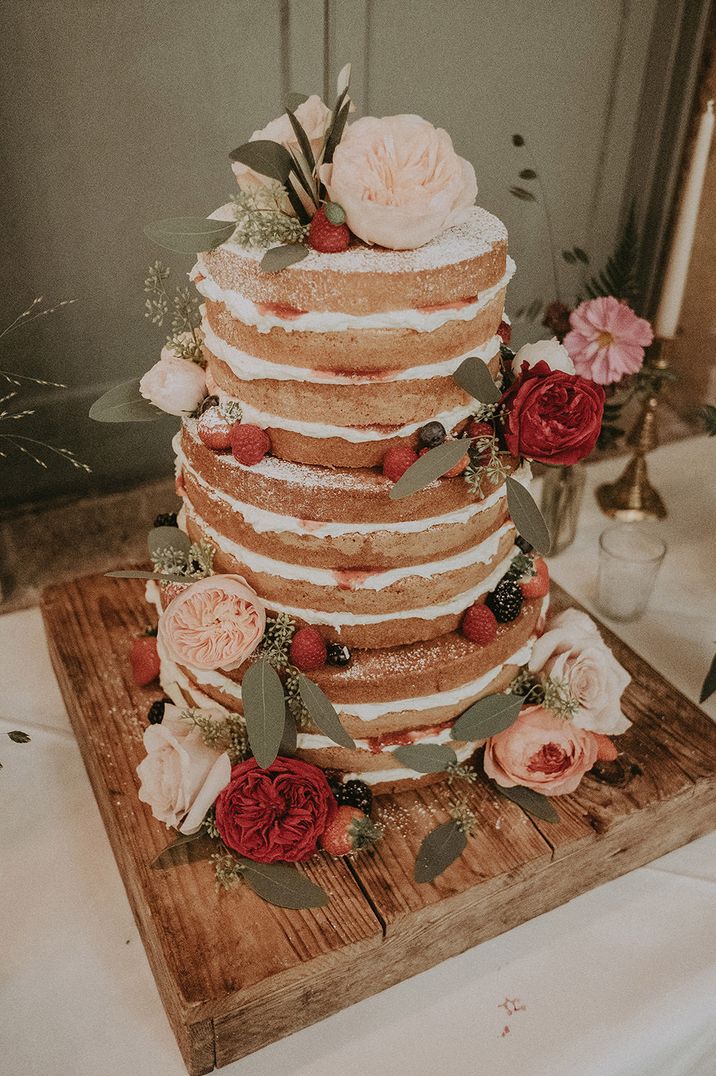 Three tier naked wedding cake with fresh buttercream and flower decor