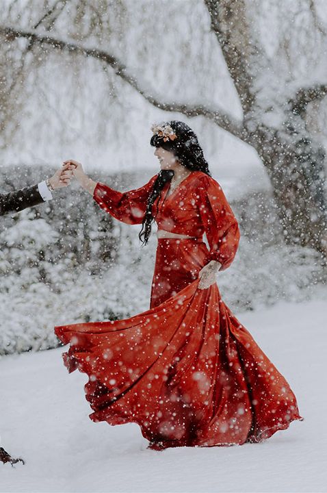 Bride and groom dance together out in the snow for their winter wedding 