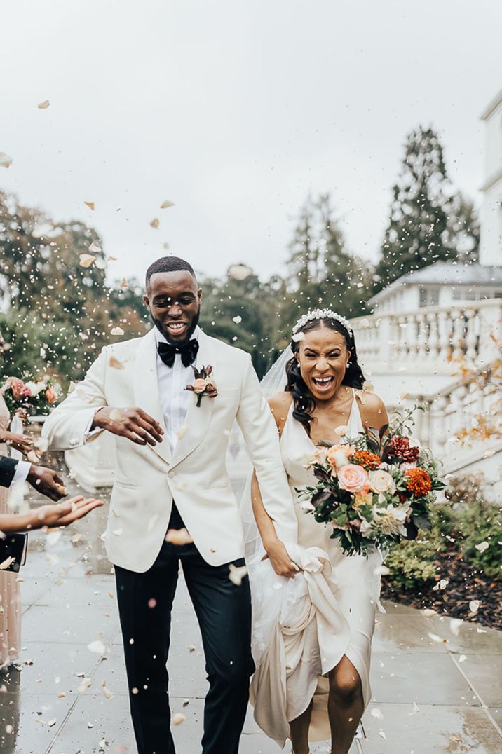 confetti moment with Black Bride in a slip wedding dress and groom in white dinner jacket 