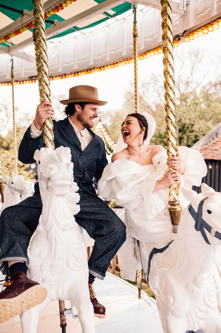 Bride and groom riding on carousel horses at carnival theme outdoor engagement party idea 