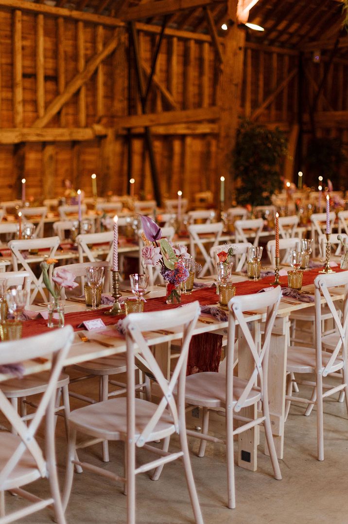 Barn venue with pastel wedding table decor with flowers and candles 