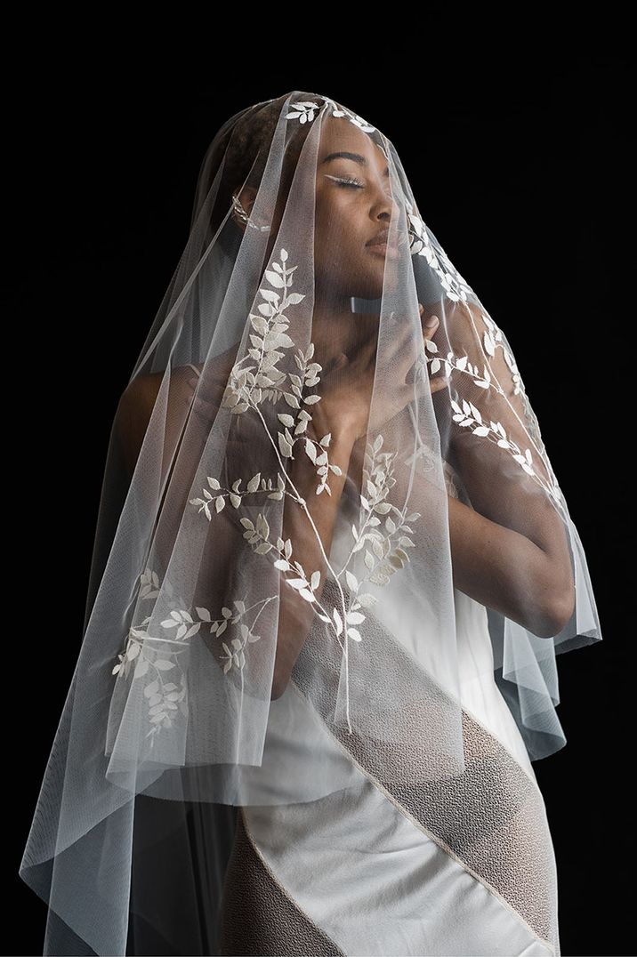 Embroidered pattern veil over black bride 